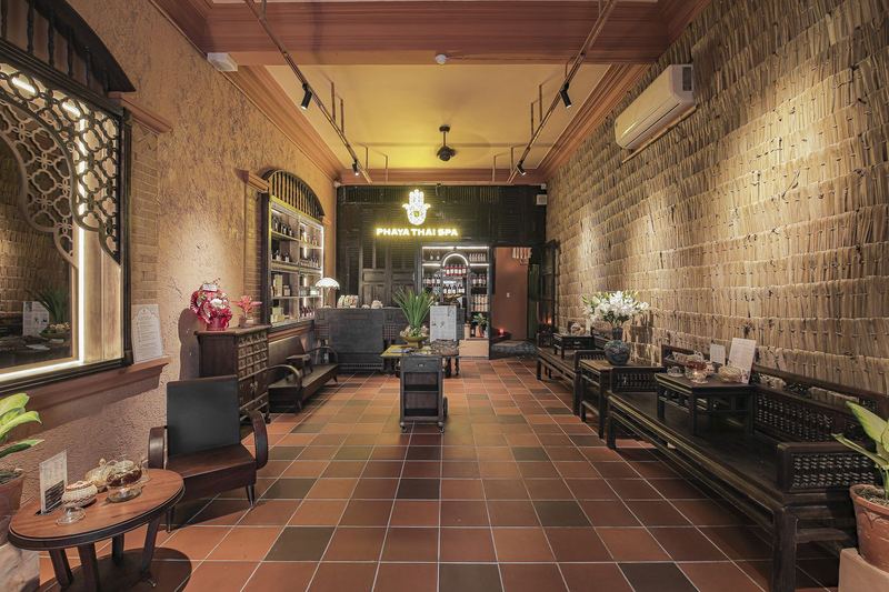Sảnh lễ tân Phaya Thai Spa Tân Bình với vách cói và kệ tinh dầu thảo mộc